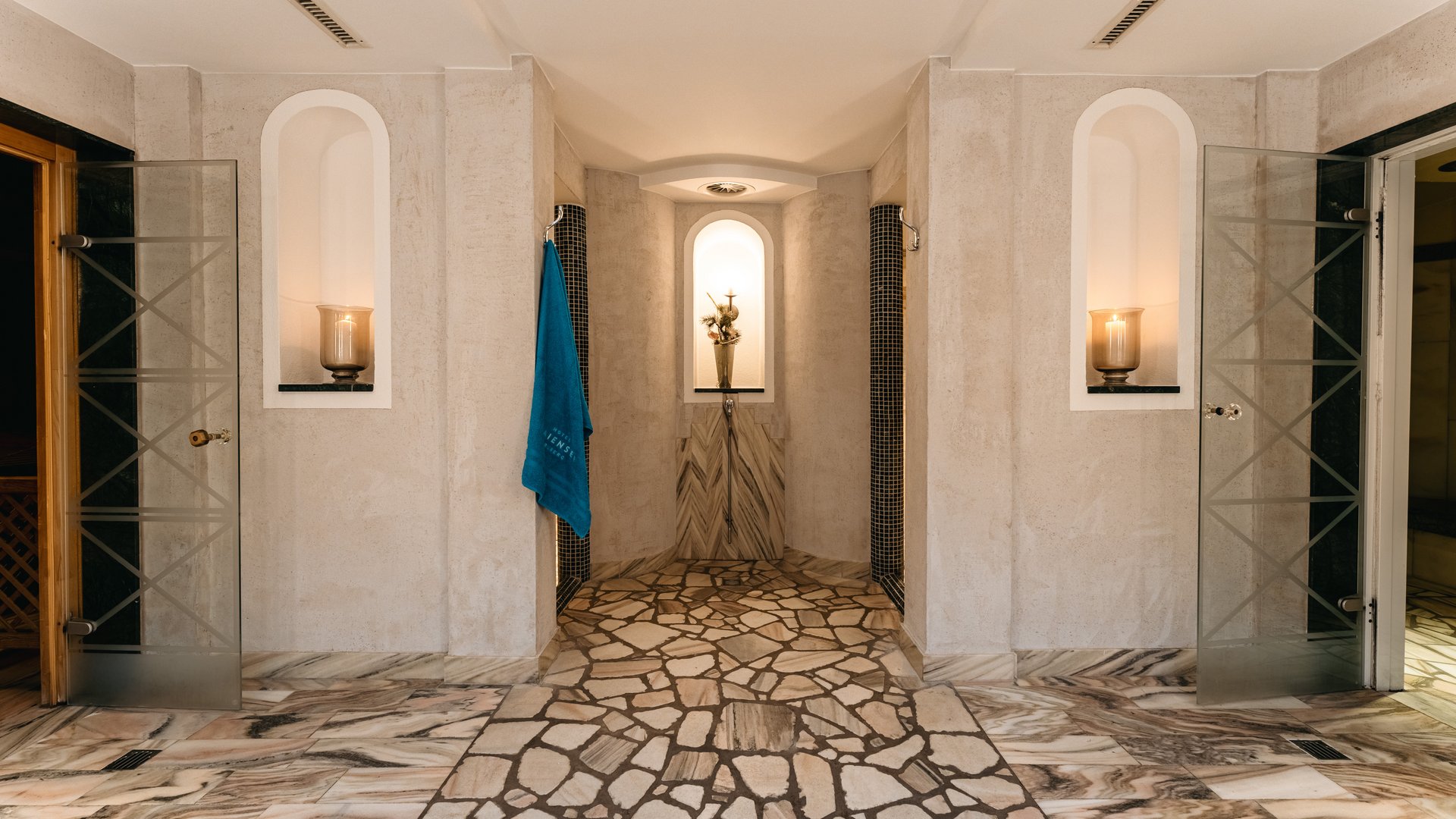 Zum Pressebereich des Hotel Maiensee Moderner Duschraum mit Mosaikboden und offenem Glastüren