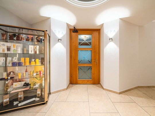 Maiensee: Ihr Wellnesshotel bei St. Anton Eingangstür zum Spa mit Produktvitrine links in hellem Flur