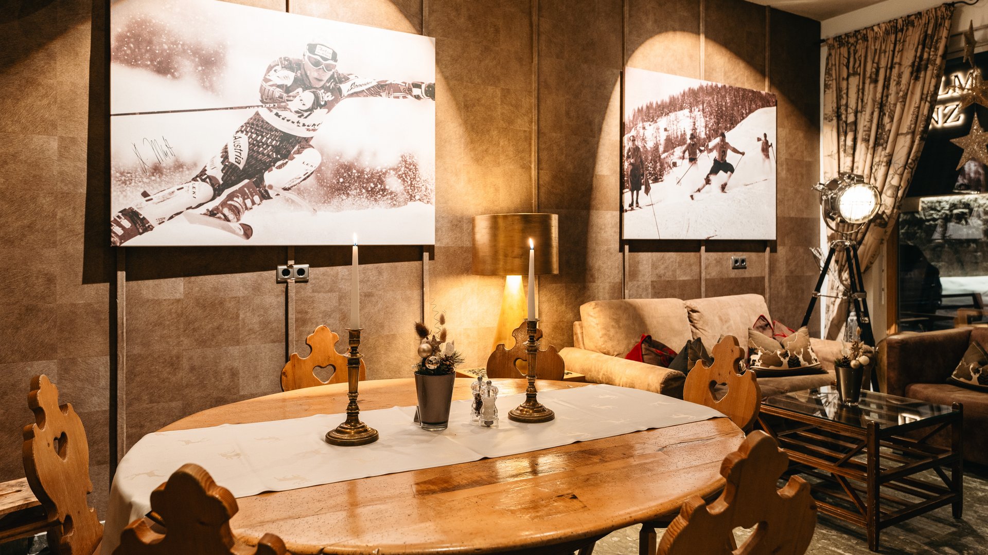 Zum Pressebereich des Hotel Maiensee Gemütlicher Raum mit Holzstühlen, Tisch und alpiner Ski-Dekoration an der Wand