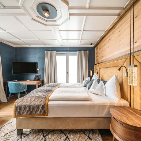 Ihre Unterkunft in St. Christoph am Arlberg: Bilder Modernes Schlafzimmer mit blauem Akzent, Doppelbett und Holzvertäfelung