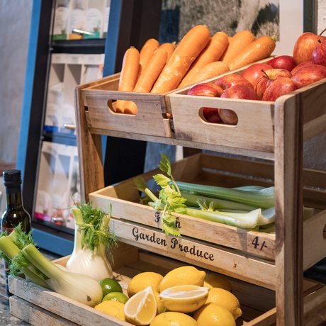 Ihre Unterkunft in St. Christoph am Arlberg: Bilder Holzregal mit Karotten, Äpfeln, Sellerie, Fenchel und Zitronen auf Küchentheke