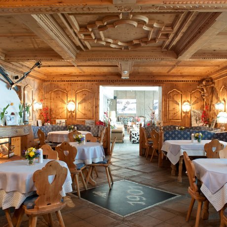 Ihre Unterkunft in St. Christoph am Arlberg: Bilder Gemütlicher Holzesstischraum mit Kamin und dekorierten Tischen