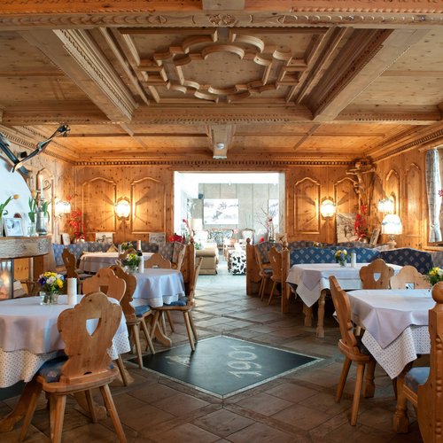 Genuss pur im 4-Sterne-Hotel in St. Anton Gemütlicher Holzspeiseraum mit Tischen und Stühlen, traditionell dekoriert