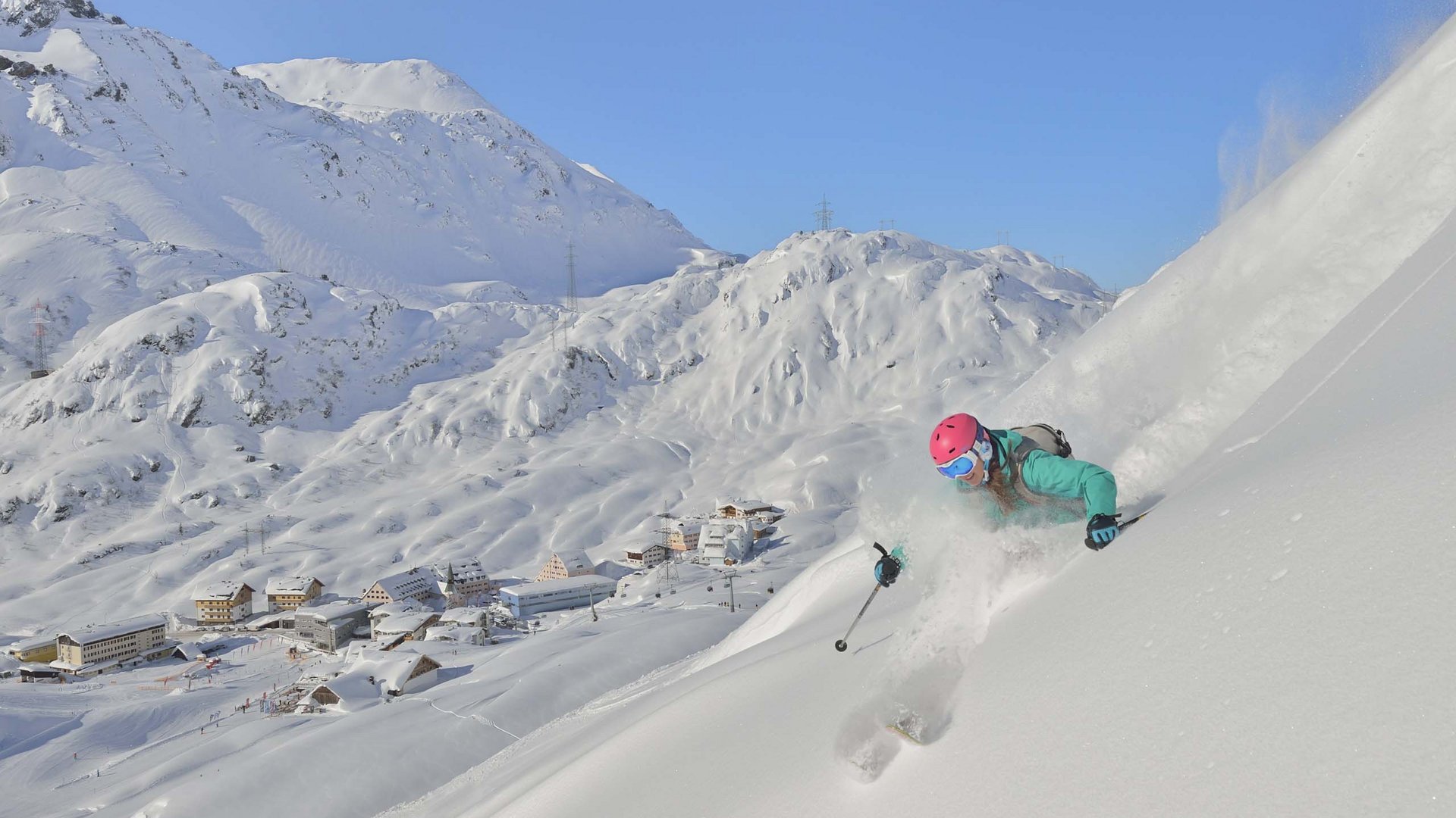 Arlberg: Ihr Hotel an der Piste Skifahrerin fährt einen schneebedeckten Hang in den Alpen hinunter