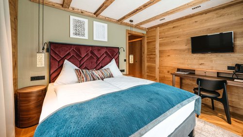 Skiurlaub am Arlberg: Anfrage Modernes Schlafzimmer mit Holzdecke, Doppelbett und Fernseher an der Wand
