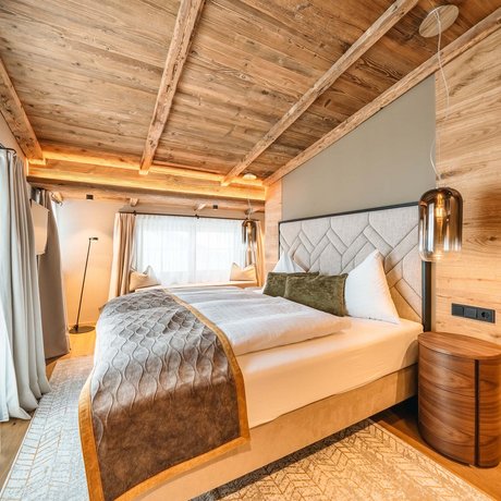 Ihre Unterkunft in St. Christoph am Arlberg: Bilder Gemütliches Schlafzimmer mit Holzbalkendecke und modernem Dekor