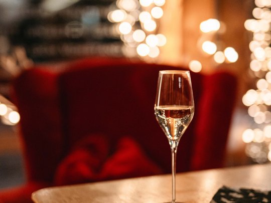 The lounge bar in your ski hotel at the Arlberg Glass of white wine on wooden table in a cozy setting