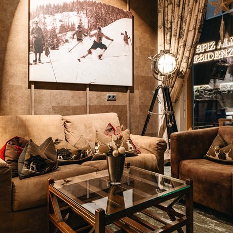 Ihre Unterkunft in St. Christoph am Arlberg: Bilder Gemütlicher Sitzbereich mit braunen Sofas und Ski-Wandbild