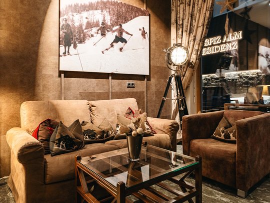 Hotel Maiensee: your hotel in St. Christoph Cozy seating area with brown sofas and skiing wall art