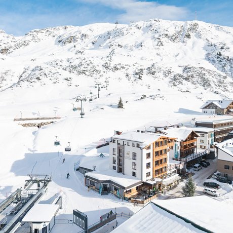 Ihre Unterkunft in St. Christoph am Arlberg: Bilder Schneebedecktes Bergdorf mit Skilift und Berg im Hintergrund