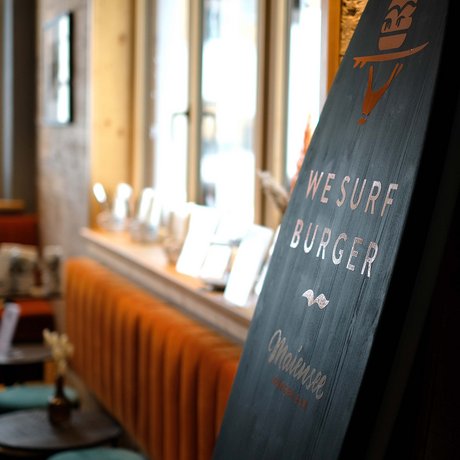 Ihre Unterkunft in St. Christoph am Arlberg: Bilder Schild mit Aufschrift We Surf Burger in moderner Burgerbar mit Sitzplätzen
