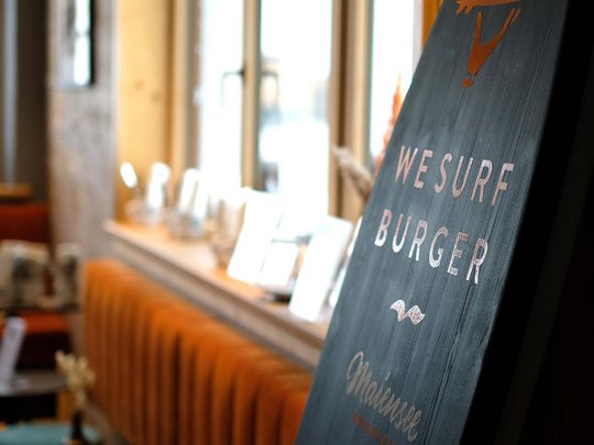 Premium burgers at the ski hotel near St. Anton am Arlberg Sign reading We Surf Burger in a modern burger bar seating area