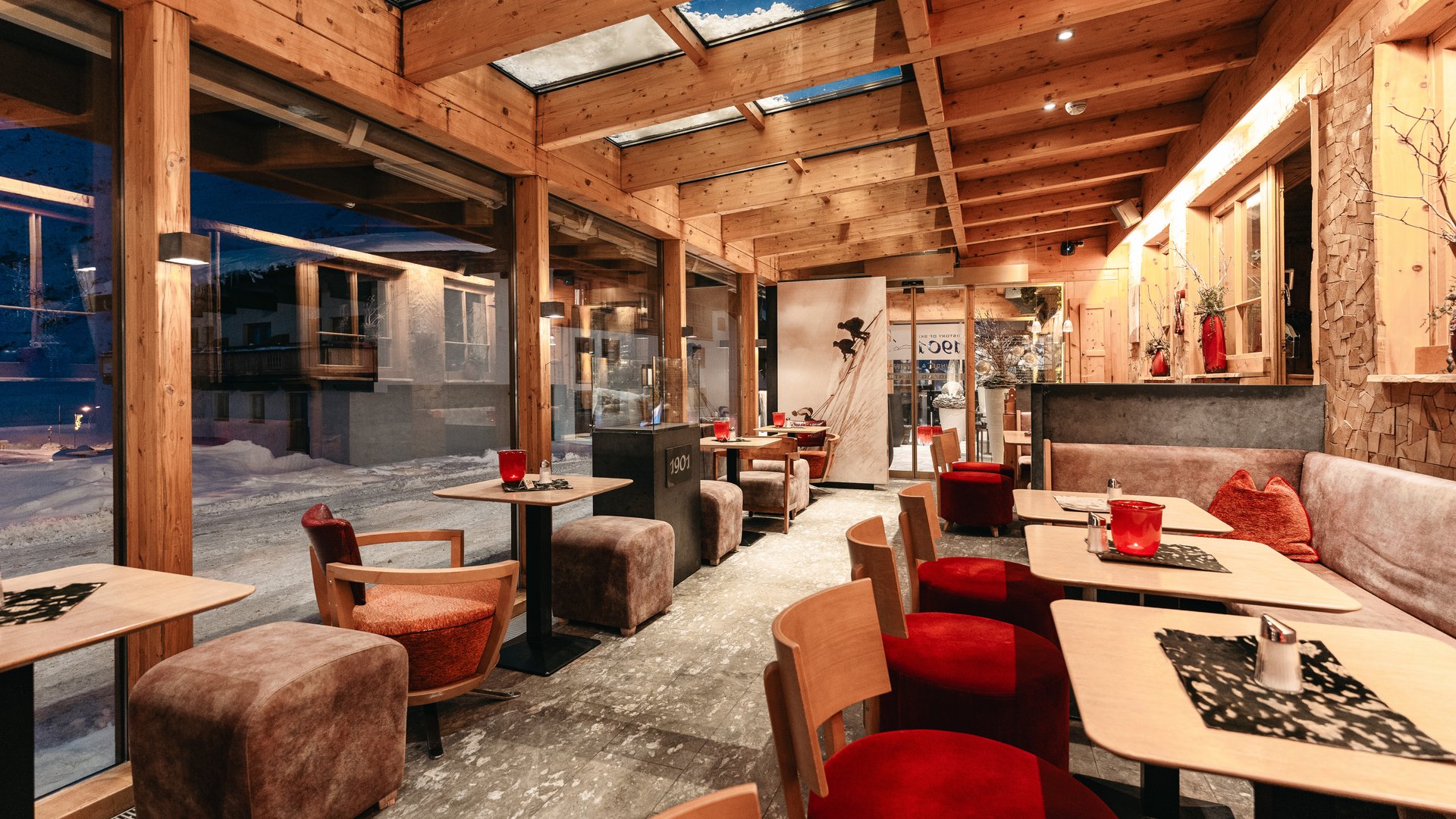 Zum Pressebereich des Hotel Maiensee Gemütliches Café mit Holzbalkendecke und Dachfenstern am Abend