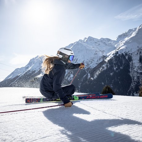 Ihre Unterkunft in St. Christoph am Arlberg: Bilder Skifahrerin rast auf präparierter Piste vor schneebedeckten Bergen bei Sonnenschein