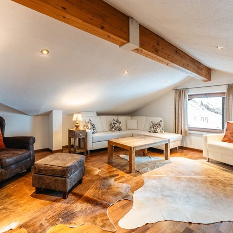 Ihre Unterkunft in St. Christoph am Arlberg: Bilder Gemütliches Wohnzimmer mit Ledersesseln und Holztisch unter Dachschräge