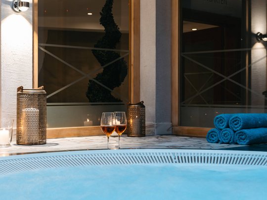 Maiensee: Ihr Wellnesshotel bei St. Anton Innenwhirlpool mit Wein, Kerzenlicht und Handtüchern in entspannter Atmosphäre