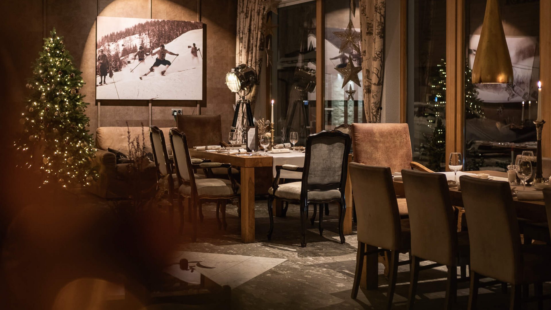 Press information for Hotel Maiensee Cozy restaurant area decorated for Christmas with tree and wooden tables