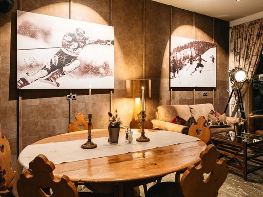 The lounge bar in your ski hotel at the Arlberg Cozy dining area with wooden table and skiing photos on the wall