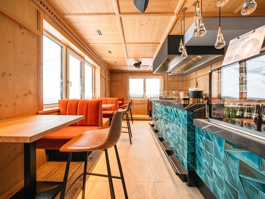 Hotel Maiensee: your hotel in St. Christoph Interior of a modern bar with orange seating and blue tiled counter
