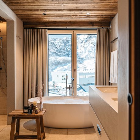 Ihre Unterkunft in St. Christoph am Arlberg: Bilder Modernes Badezimmer mit Badewanne vor Fenster mit Bergblick