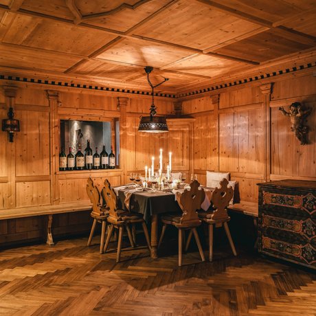 Ihre Unterkunft in St. Christoph am Arlberg: Bilder Gemütlicher Holzesstisch mit Kerzen und Weinflaschen in einem rustikalen Zimmer