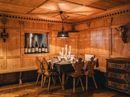 Hotel Maiensee: your hotel in St. Christoph Cozy wooden dining table with candles and wine bottles in a rustic room