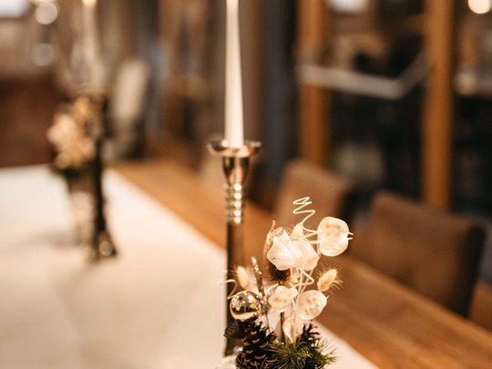 The lounge bar in your ski hotel at the Arlberg Candle and decorative flower pot on a set wooden dining table