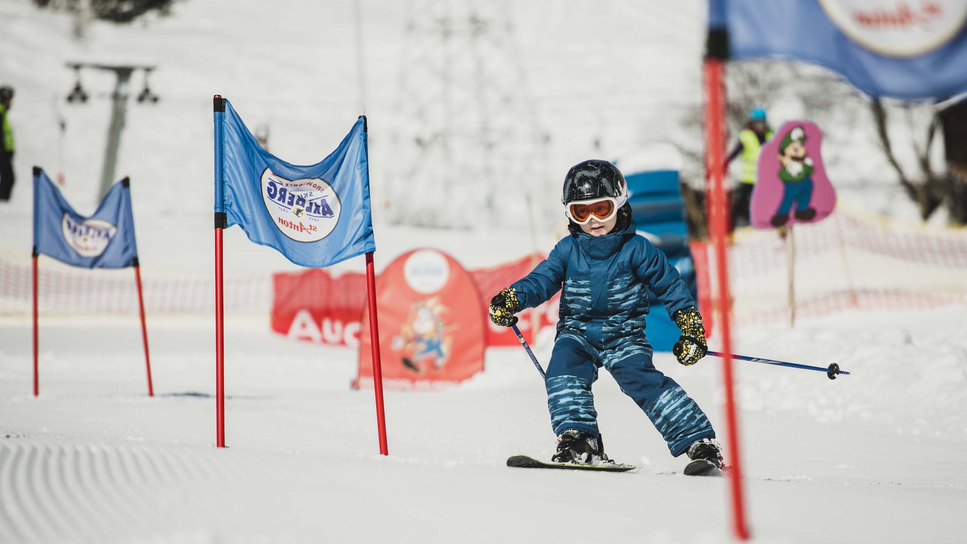 Arlberg: Ihr Hotel an der Piste Kleines Kind lernt Skifahren zwischen blau-roten Trainingsfahnen im Schnee