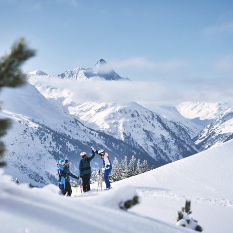 Ihre Unterkunft in St. Christoph am Arlberg: Bilder Gruppe von Skifahrern auf verschneitem Berg mit Alpen und wolkigem Himmel im Hintergrund
