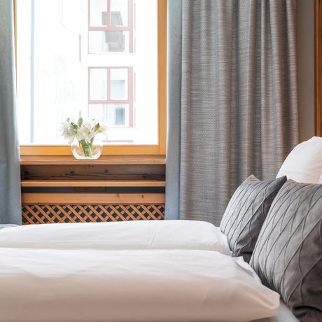 Ihre Unterkunft in St. Christoph am Arlberg: Bilder Gemütliches Schlafzimmer mit frischer Bettwäsche, Kissen und Blumen auf der Fensterbank