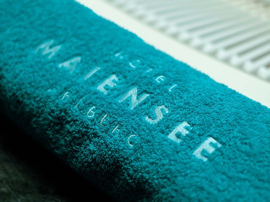 Hotel Maiensee: wellness near St. Anton am Arlberg Blue towel with text on the edge of a swimming pool