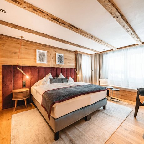 Ihre Unterkunft in St. Christoph am Arlberg: Bilder Gemütliches Schlafzimmer mit Holzwänden, Doppelbett und großem Fenster