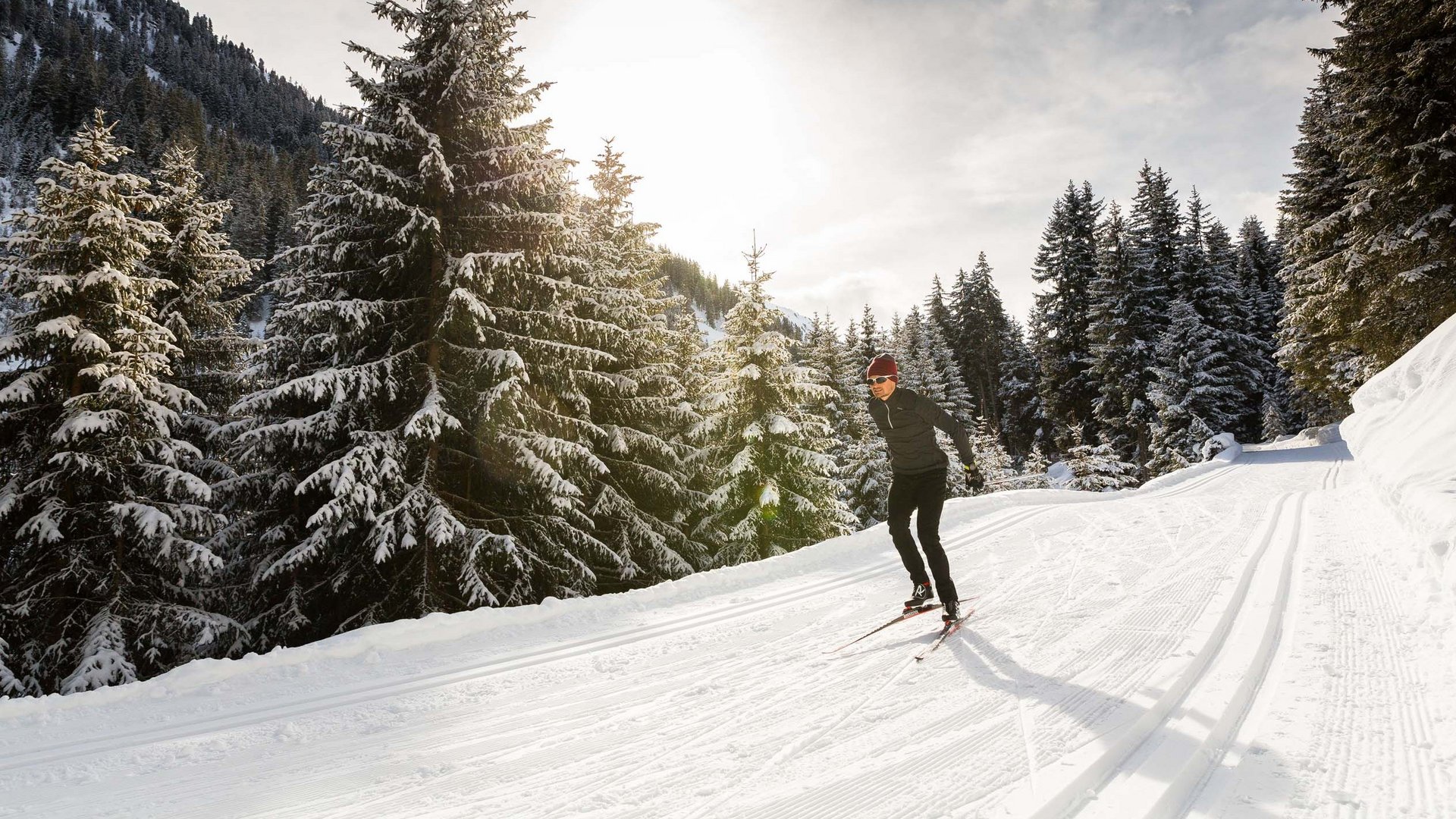 Hotel Maiensee: winter sports at the Arlberg Skier on snowy trail in sunny winter forest
