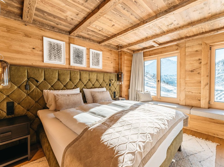 Hotel Maiensee: your hotel in St. Christoph Cozy bedroom with wooden walls and mountain view through large windows