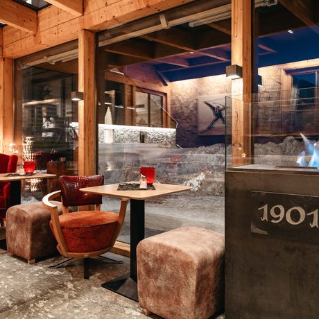 Ihre Unterkunft in St. Christoph am Arlberg: Bilder Gemütliche Sitzecke mit Kamin und großen Fenstern in einem Holzhaus