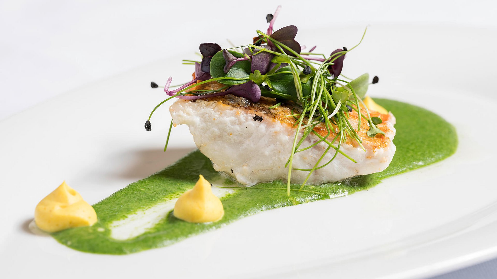 Maiensee, Ihr Hotel in Sankt Christoph: Kulinarik Gebratenes Fischfilet mit grüner Sauce, Kräutern und zwei kleinen Dips auf weißem Teller