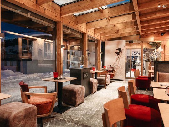 Hotel Maiensee: your hotel in St. Christoph Cozy café with wooden ceiling and large windows overlooking snowy street