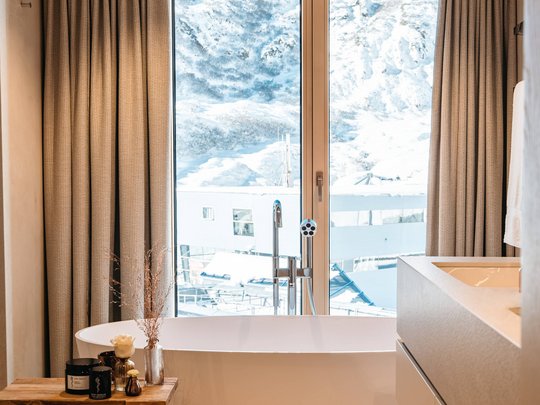 Your hotel in St. Christoph am Arlberg Modern bathtub with view of snow-covered mountains through window