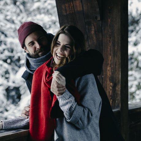 Ihre Unterkunft in St. Christoph am Arlberg: Bilder Paar umarmt sich auf Balkon mit Schnee und Tannen im Hintergrund