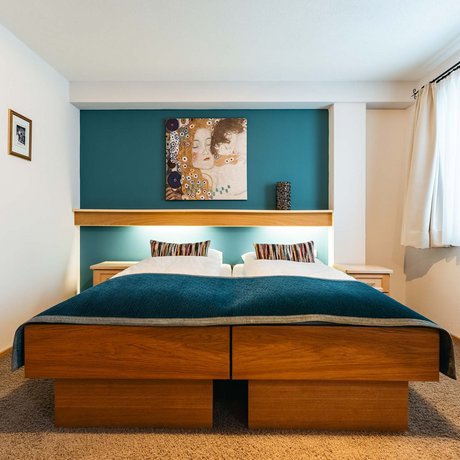 Ihre Unterkunft in St. Christoph am Arlberg: Bilder Gemütliches Schlafzimmer mit Doppelbett, blauem Wandbild und Tageslichtfenster