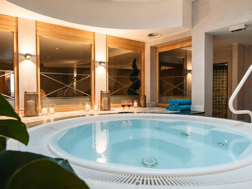 Your hotel in St. Christoph am Arlberg Round hot tub in a modern spa room with candles and towels