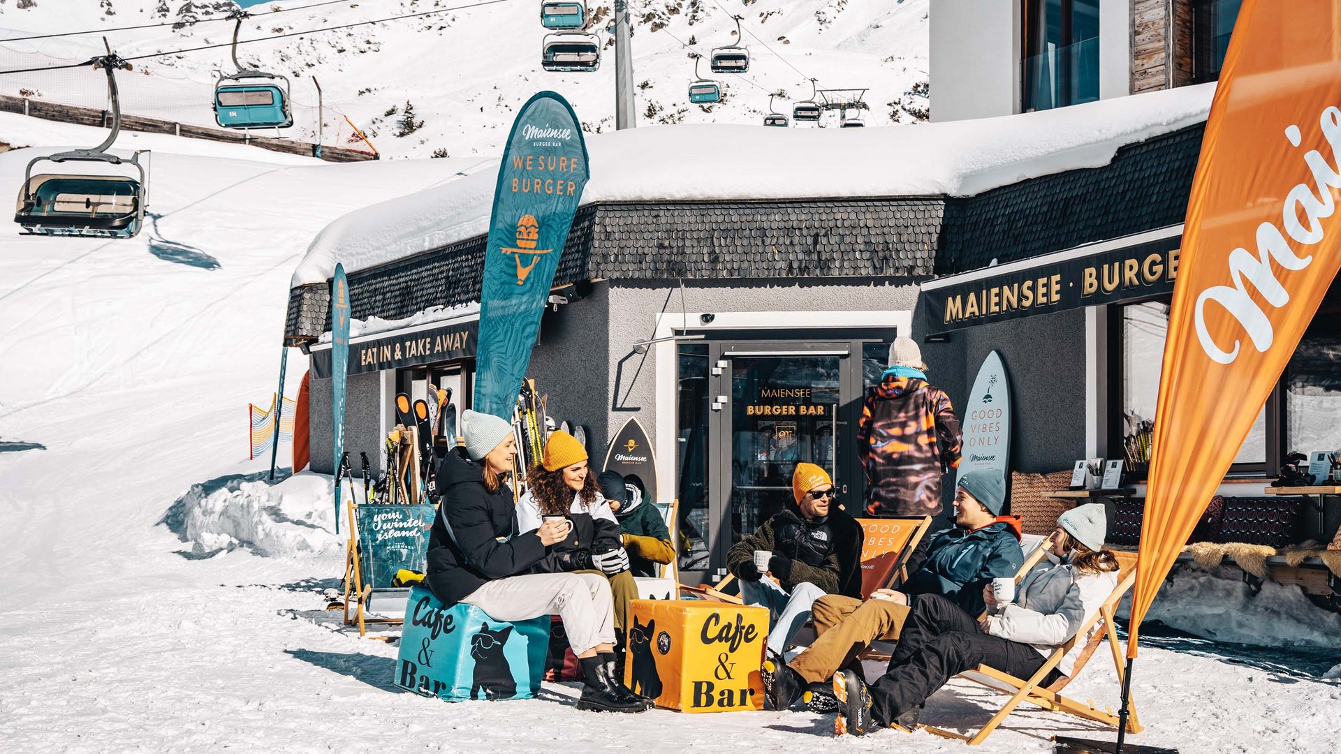 Premium burgers at the ski hotel near St. Anton am Arlberg Group of people sitting outside a mountain café in the snow