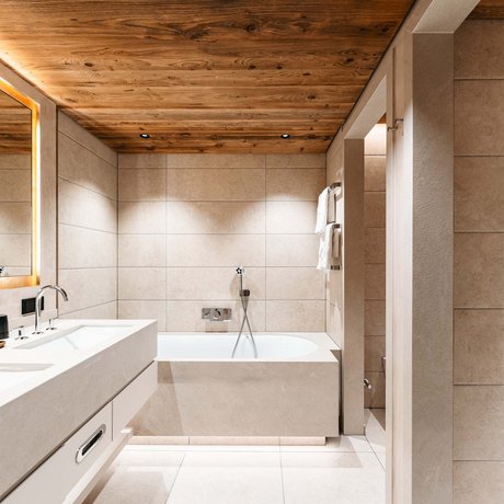 Ihre Unterkunft in St. Christoph am Arlberg: Bilder Modernes Badezimmer mit Holzdecke, Doppelwaschbecken und Badewanne.