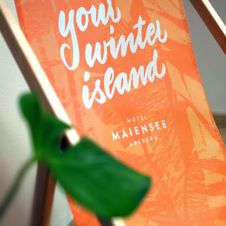 Ihre Unterkunft in St. Christoph am Arlberg: Bilder Oranger Liegestuhl mit Aufschrift Hotel Maiensee Arlberg