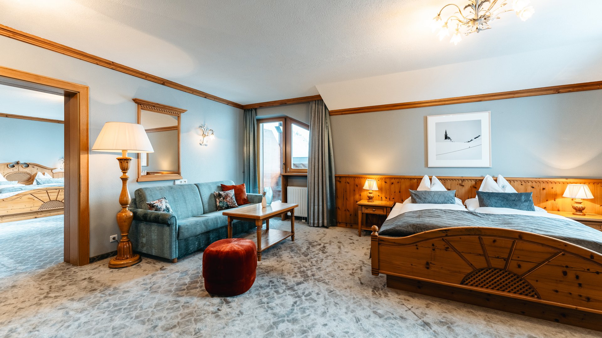 Zum Pressebereich des Hotel Maiensee Gemütliches Hotelzimmer mit Holzmöbeln, Sofa und Doppelbett