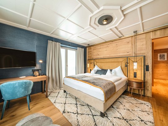 Hotel Maiensee: your hotel in St. Christoph Cozy bedroom with wooden walls, double bed, and wall-mounted TV