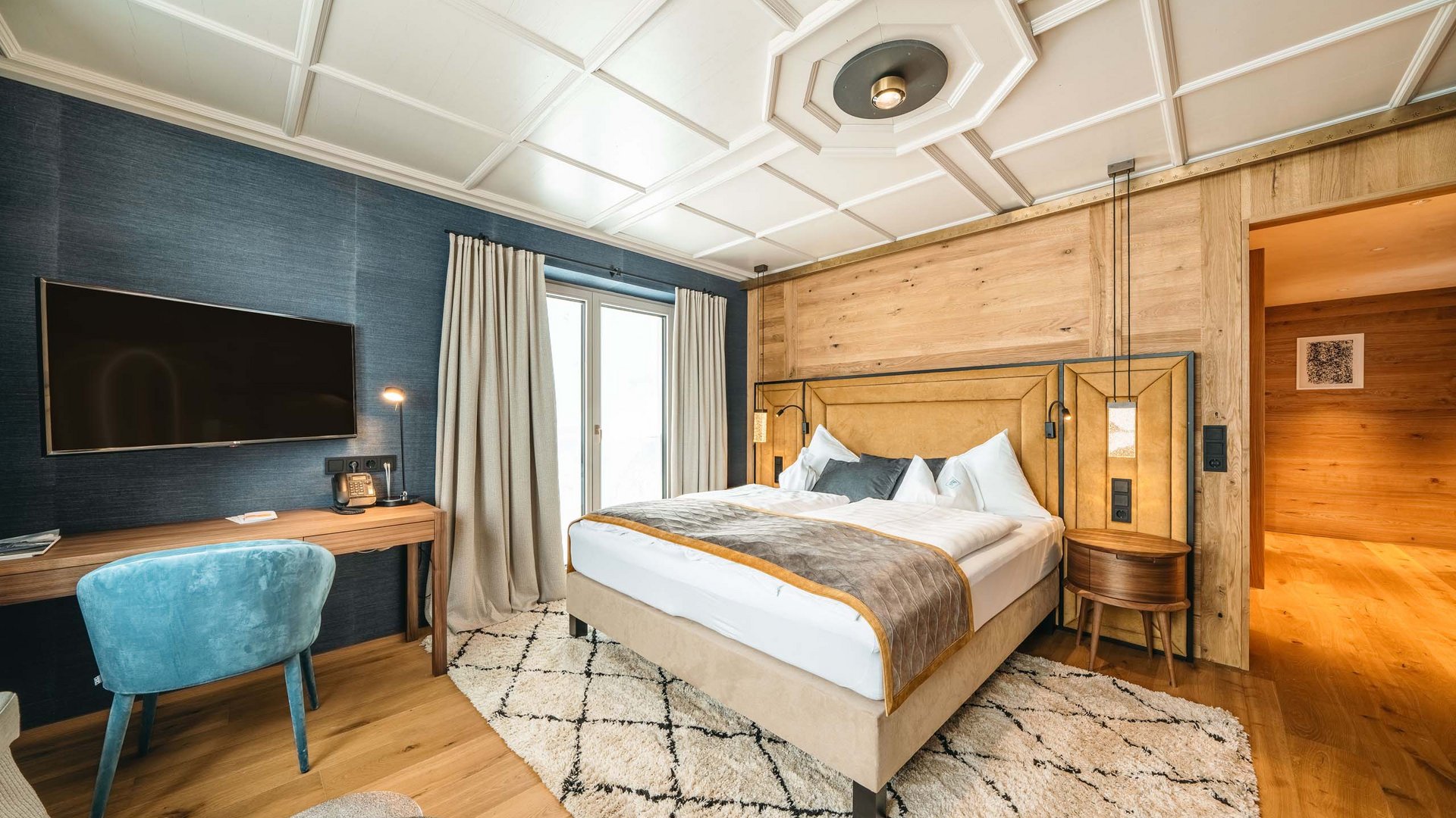 Hotel Maiensee: your hotel in St. Christoph Cozy bedroom with wooden walls, double bed, and wall-mounted TV