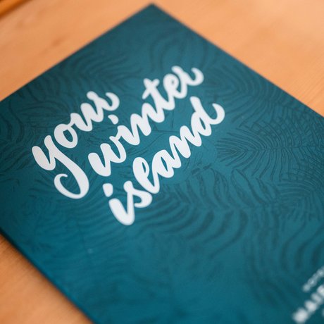 Ihre Unterkunft in St. Christoph am Arlberg: Bilder Grünes Blatt mit dem Schriftzug your winter island auf einem Holztisch